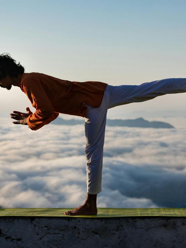 Silhouette of a man stretching against a sunrise, evoking a sense of calm and wellness.
